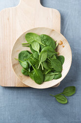 Wooden bowl of spinach leaves on wooden board - MYF001381