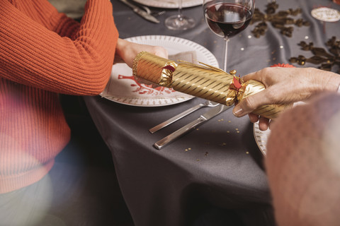 Zwei Frauenhände, die an den Enden eines Weihnachtsgebäcks ziehen, lizenzfreies Stockfoto