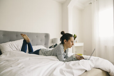 Entspannte Frau im Bett liegend mit Laptop - EBSF001236