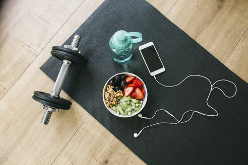 Dumbbell, drinking bottle, fruit bowl and smartphone with earphones - EBSF001258