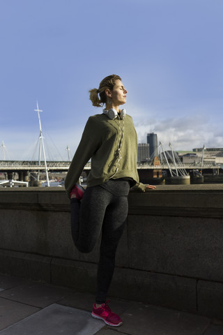 UK, London, Läuferin beim Stretching am Riverwalk, lizenzfreies Stockfoto