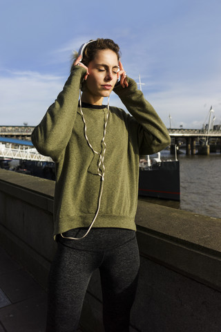 UK, London, Läuferin hört Musik am Riverwalk, lizenzfreies Stockfoto