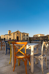 Sicily, Marzamemi, tables and chairs of restauraunt, chapel in the background - CSTF001017