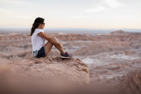 Chile, San Pedro de Atacama, woman sitting on rock in the Atacama desert - MAUF000346