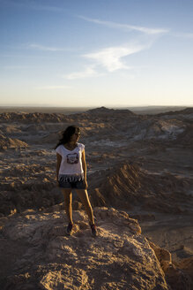 Chile, San Pedro de Atacama, Frau steht auf einem Felsen in der Atacama-Wüste - MAUF000367