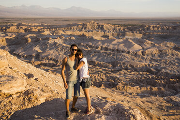 Chile, San Pedro de Atacama, Paar auf einem Felsen in der Atacama-Wüste stehend - MAUF000368