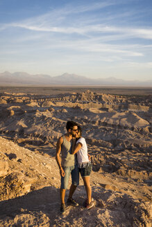 Chile, San Pedro de Atacama, Paar auf einem Felsen in der Atacama-Wüste stehend - MAUF000369