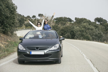 Frauen haben Spaß in einem Cabrio auf einer Landstraße - ABZF000277