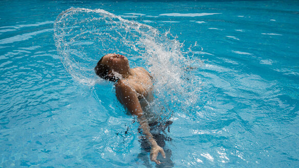 Junge, der in einem Schwimmbad mit Wasser plantscht - WGF000835