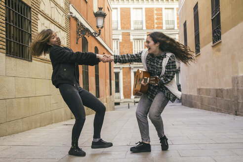 Spanien, Madrid, zwei Frauen tanzen auf einer Straße - ABZF000283