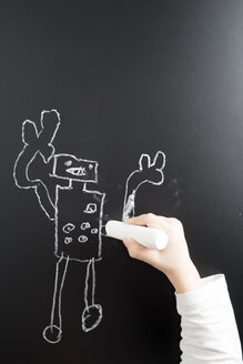 Hand eines kleinen Jungen, der einen Roboter auf eine Tafel zeichnet - MYF001395