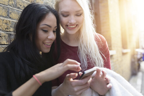 Zwei beste Freundinnen schauen auf ihr Handy - BOYF000195