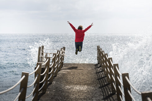 Portugal, Madeira, woman jumping on pier - MKFF000287