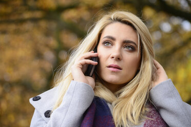 Portrait of young woman in autumn telephoning with smartphone - LFOF000184