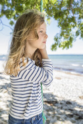 Portrait of blond girl standing on a swing on beach - OJF000126