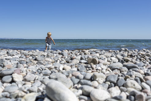 Kleiner blonder Junge läuft am steinigen Strand - OJF000129