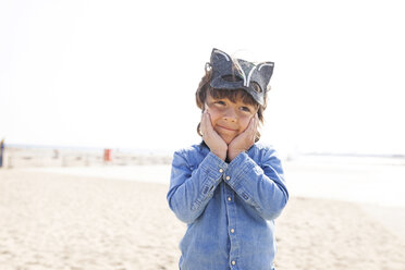 Kleiner Junge mit einer Tiermaske, der am Strand posiert und lustige Gesichter macht - VABF000367
