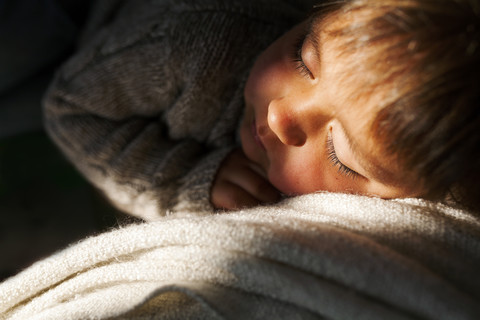 Kleiner Junge schläft auf der Couch, lizenzfreies Stockfoto