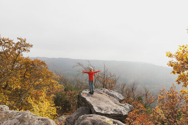 Deutschland, Rheinland-Pfalz, Pfälzerwald, Frau übt Yoga auf dem Drachenfels im Herbst - GWF004645