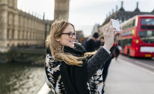 UK, London, junge Frau macht ein Selfie auf der Westminster Bridge - MGOF001544