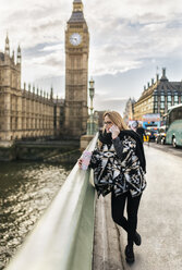 UK, London, junge Frau telefoniert auf der Westminster Bridge - MGOF001547