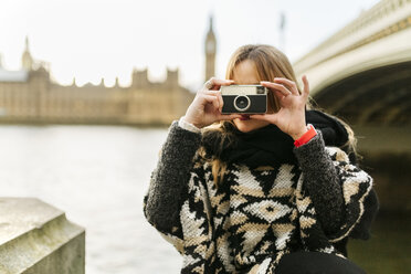 UK, London, young woman taking a picture near Westminster Bridge - MGOF001559