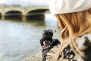 UK, London, young woman using her smartwatch near Westminster Bridge - MGOF001560