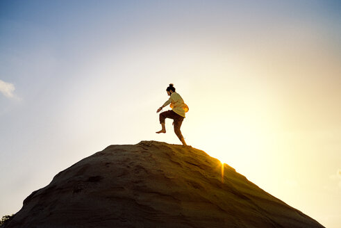 Man with bun running uphill - BMAF000094