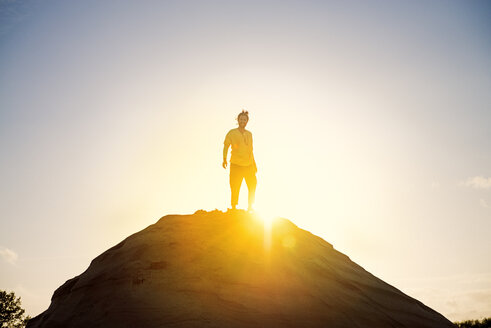 Man standing on hill against sunset - BMAF000096