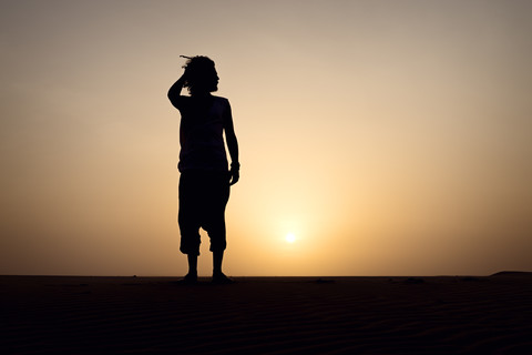 Silhouette eines auf einer Düne stehenden Mannes, lizenzfreies Stockfoto