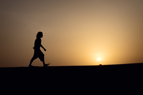 Silhouette eines auf einer Düne gehenden Mannes, lizenzfreies Stockfoto