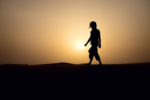 Silhouette of man walking on dune - BMAF000127