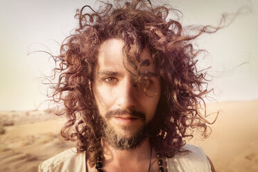 Porträt eines Mannes mit Bart und lockigem Haar in der Wüste - BMAF000130