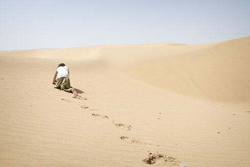 Man crawling on all fours alone in the desert - BMAF000131