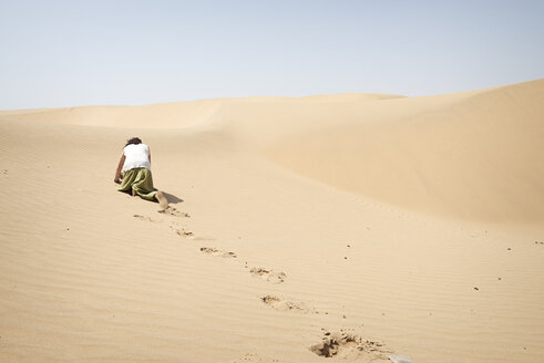 Mann kriecht auf allen Vieren allein durch die Wüste - BMAF000131