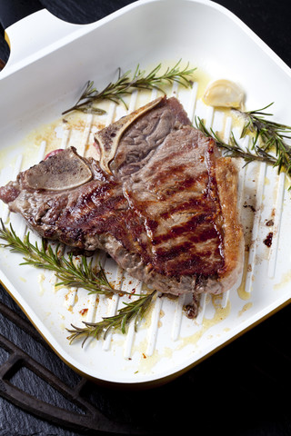 Porterhouse steak with rosmary and garlic in grill pan stock photo