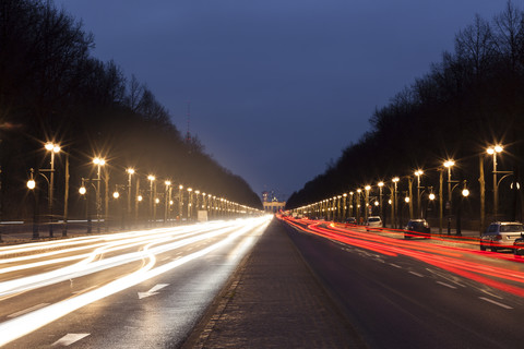 Deutschland, Berlin, Blick zum Brandenburger Tor, Straßenverkehr und Lichtspuren am Abend, lizenzfreies Stockfoto