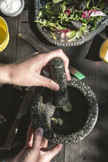Frühlingssalat aus Babyspinat, Kräutern, Rucola und Kopfsalat, gehackter Knoblauch im Mörser - DEGF000702