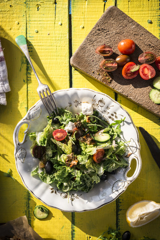 Griechischer Salat mit Rucola, Käse, Oliven, Tomaten, Gurken, Zwiebeln und karamellisierten Nüssen, lizenzfreies Stockfoto