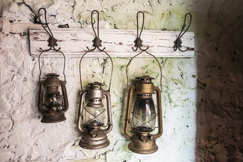 Old vintage storm lamps on painted stone wall - DEGF000757