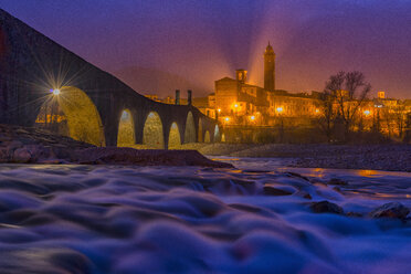 Italien, Provinz Piacenza, Bobbio, Ponte Vecchio und die Stadt Bobbio am Abend - LOMF000244