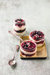 Glasses of vanilla cream with berry sauce and chopped almonds - MYF001418