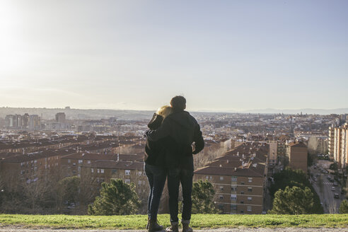 Spanien, Madrid, Rückenansicht eines jungen verliebten Paares auf einem Hügel mit Blick auf die Stadt - ABZF000290