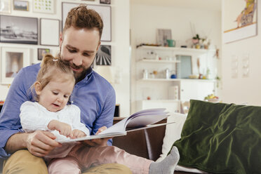 Vater und kleines Mädchen lesen ein Buch zu Hause - MFF002882
