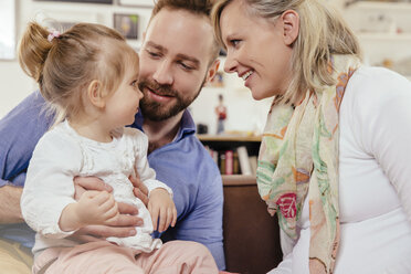 Expectant parents talking about mother's pregnancy with their little daughter - MFF002896