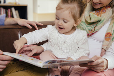 Eltern lesen einem kleinen Mädchen ein Buch vor - MFF002898