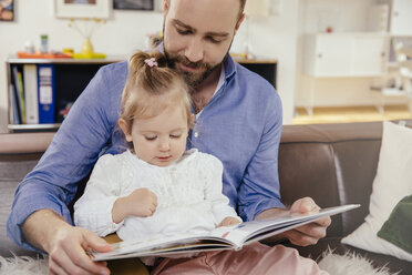 Vater und kleines Mädchen lesen ein Buch zu Hause - MFF002899