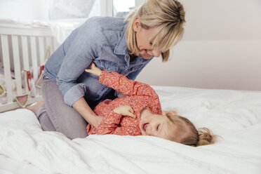 Mutter und Tochter kuscheln auf dem Bett - MFF002904