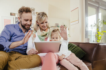 Eltern und kleine Tochter skypen mit digitalem Tablet zu Hause - MFF002913