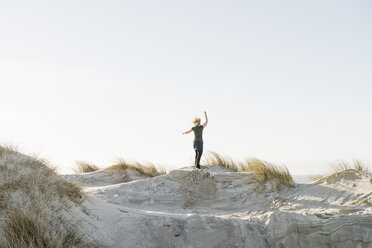 Denmark, Henne Strand, Happy woman standing on sand dune - BMA000183